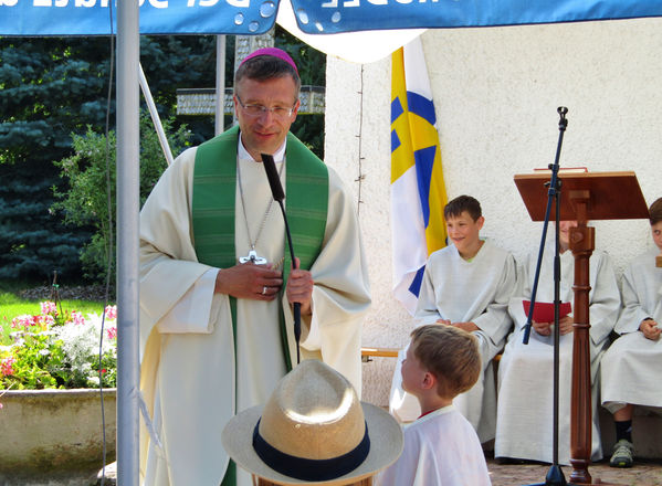 Kinder erzählen dem Bischof, was sie beim Familiencamp erlebt haben.